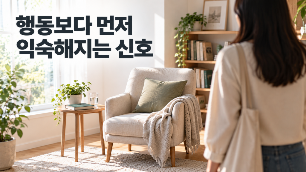 습관 형성에서 신호가 행동보다 먼저 학습되는 과정 2 익숙한 독서 공간을 바라보는 인물과 의자 옆에 놓인 책을 통해 습관 형성 과정에서 주변 환경이 행동을 떠올리게 하는 신호로 작용하는 모습을 표현한 이미지